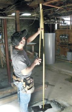 A week passes before I can install the columns. To get a fast measurement, I stack the cap and base plates together on the footing and measure up.