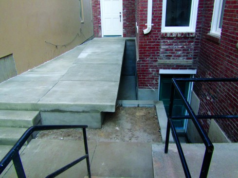 It's important to account for where the water goes once it drains off the roof. In this case, overflow was directed right into the basement. A small entryway roof was installed to keep the basement area dry.