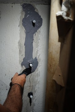 Connecting the dots, Toby spreads the epoxy paste along the length of the crack.