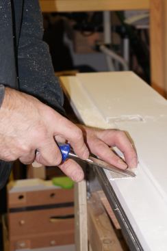 A sharp chisel or knife removes the bits of wood left from the corner chisel, making the mortise ready for a square-corner hinge.