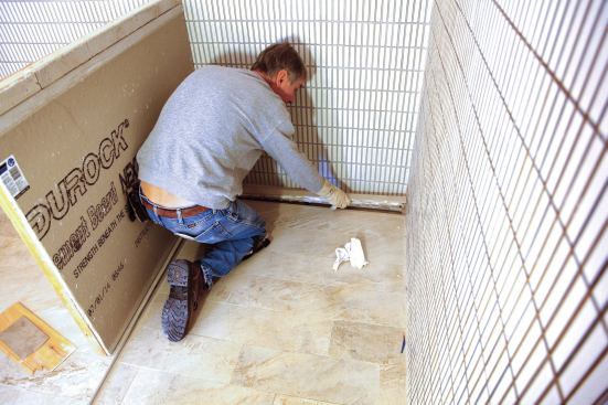 It is also possible in a curbless shower to position a linear drain against the wall opposite the opening of the shower.