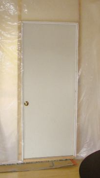 A weatherstripped hollow-core door is a better choice for heavily used openings between living space and work area.
