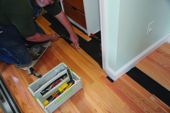 After it's cut to the scribe lines, the piece is tapped into place using a scrap block to protect the end.