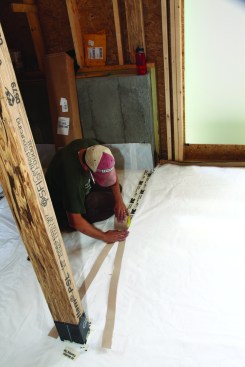 The crew laid out the poly sheets so the seams broke near the lines of columns wherever possible; as they taped the seams, the crew carefully
unrolled the tape with the backing split to keep the roll centered on the seam.