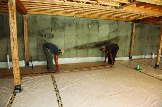 The first course of subfloor sheets was then set on the snapped line.