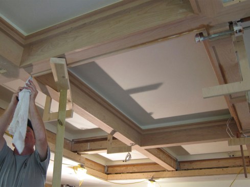 Floor-to-ceiling springboards and clamps hold the completed boxes in place.