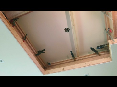 At outside corners, the two-way projection of the false ceiling’s perimeter prevented the insertion of a preassembled frame (a minimum of three sides clear was needed), so the trim build-out had to be installed in place.