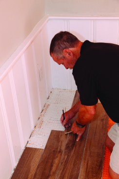 To finish each four-course section, the author marked the lengths of the last tiles in place before cutting and installing them, making sure to leave a 1/4-inch expansion space near the wall.