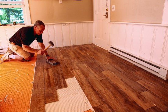 He tapped the ends of all the tiles with the block and a rubber mallet until their edges were even.