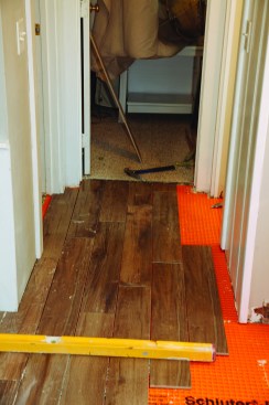 The floor of an adjacent hallway was slightly out of level, and for this small area, the author opted to use a mechanical “Lippage Tuning” system from Miracle Sealants. First, he cut and dry-fit all the tile for the hallway space.
