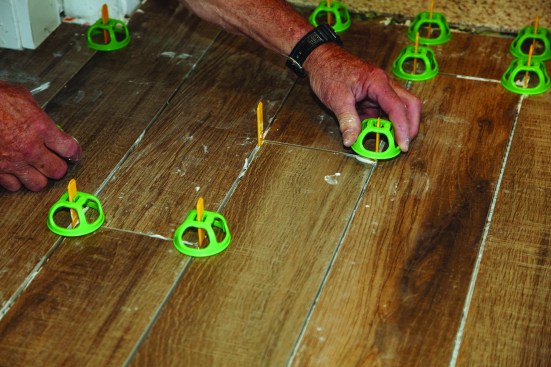 After all the tiles were in place, he pushed plastic caps down over the protruding tabs.