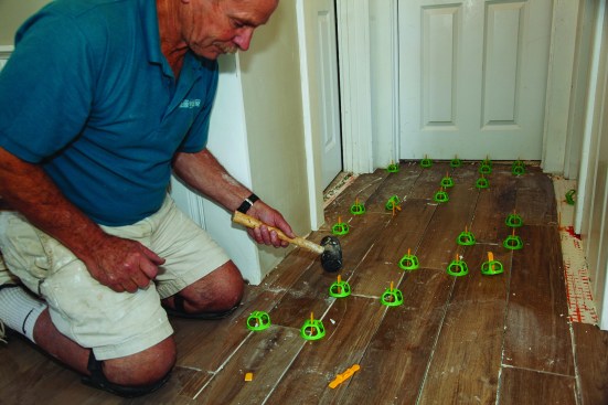 Each spacer has a breakaway point; once the thinset had cured, a gentle tap with a mallet broke off the tab below the grout line.