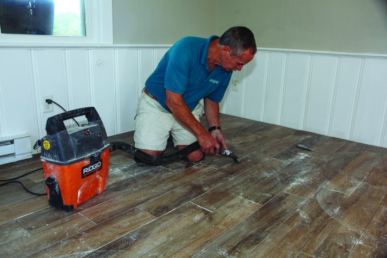 He used a vacuum to pull the loosened pieces out of the grout lines.