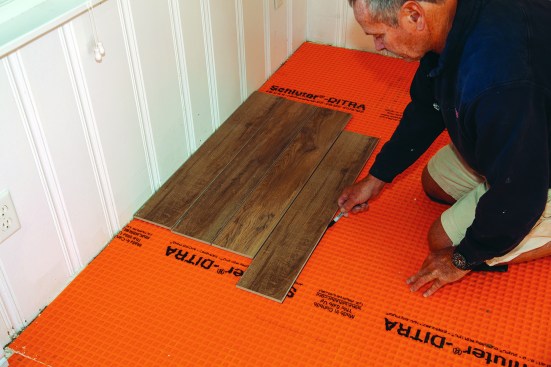 For this project and this type of tile, the author installed four courses at a time. To lay out each section, he set four tiles in place and measured across them.