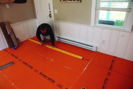 That measurement then guided his layout line for installing each four-course section across the floor.