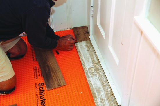 Tiles for the first course had to be scribed around the threshold of the door.