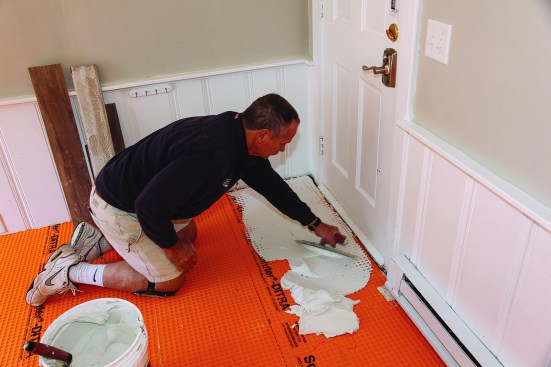 Installation of tile over this uncoupling membrane required two passes of dry-set mortar—thinset that needs to be used over the membrane. The first pass with the flat edge of the trowel forced thinset into the cavities of the membrane.