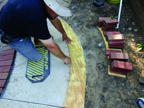 When the slab was done, he set the template on the concrete and marked out the positions of the bricks.