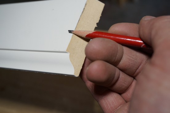 Running a pencil along the edge of the profile highlights the edge that will guide the cope cuts.