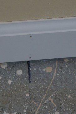 At each stud location one nail is driven into the wall plate near the bottom edge of the molding, and a second nail about 1/4 inch below the curved profile anchors the baseboard to the wall stud/