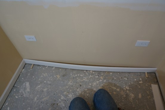 Ideally the lengths of baseboard should have a slight spring to them. When the board is nailed to the wall, that spring disappears and helps to close the coped corner joint on the left.