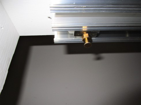 A flanged pin hanging down from the rollers slides into a slot on the door hardware.