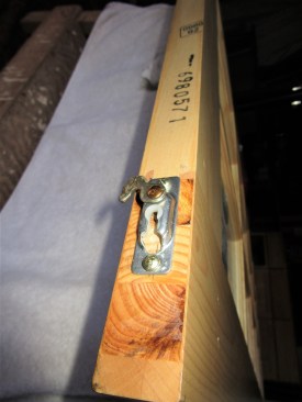 The hardware at the top of the door has a slot where the roller pin inserts. A clip rotates to lock the pin in place.