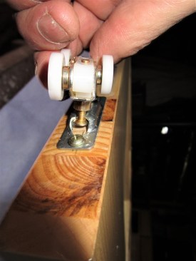 The author demonstrates the roller pin engaging the door hardware. Each door has two rollers that hold the door. Two wheel side of the rollers is alternated to keep the load distributed evenly.