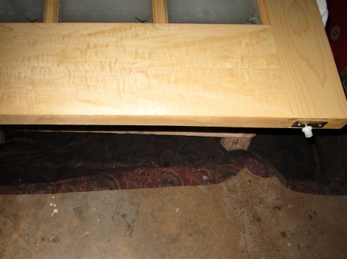 Plastic guides screwed to the bottoms of the door panels ride in the guide tracks on the floor. 