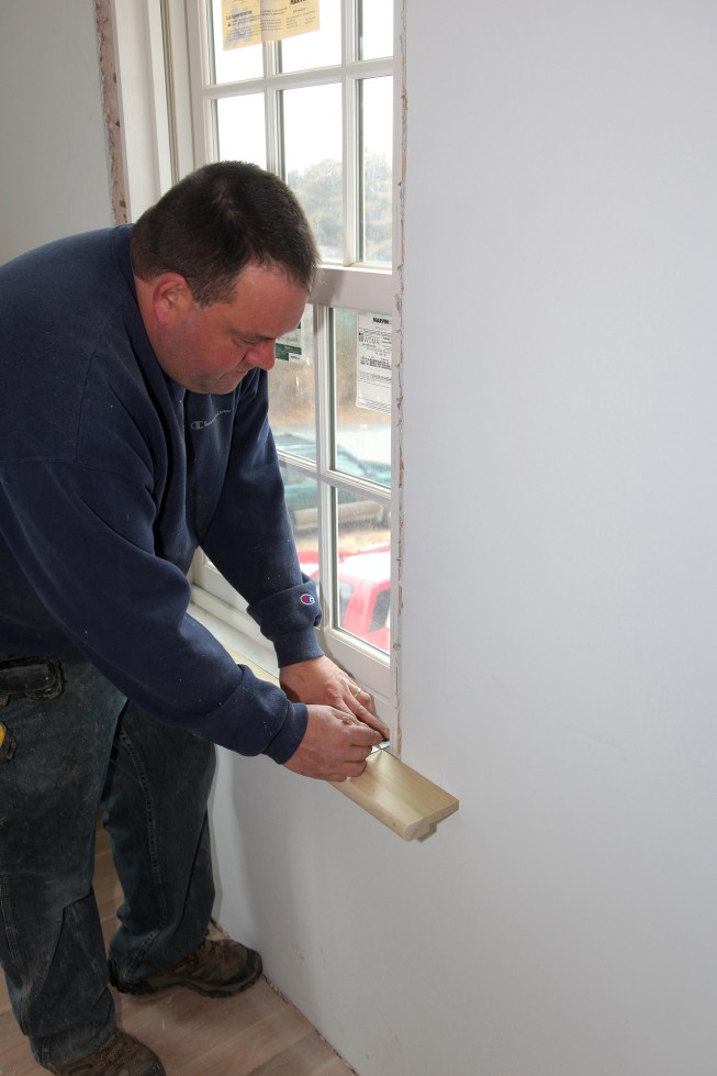 After cutting stool stock to a rough length, hold it in place against the wall and measure the distance from the back of the stool to the edge of the window. Holding your ruler against the window jamb, draw a line for the inside edge of the jamb. 