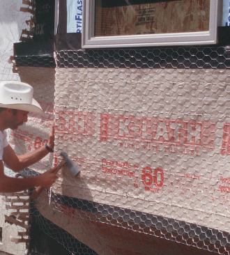 Paper-backed lath then butts directly to the window flange, but water that gets behind the stucco at the window sill and jamb will be handled by the membrane, the flashing, and the first layer of paper.