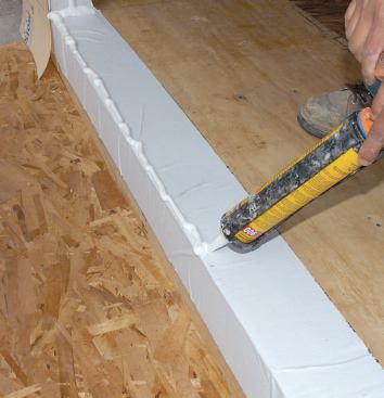 In the barrier method, polyurethane sealant is applied in two continuous 5/8-inch-diameter beads all the way across the door pan and 6 inches up both trimmers, one toward the front of the rough opening and one toward the rear.