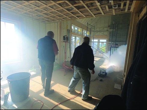 To begin a “smoke check,” the authors fill a home with dense fog produced by a high-volume theatrical fog machine.
