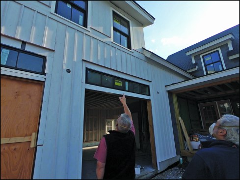 Co-author Jim Bradley points to smoke leaking from double-hung windows in living space above the garage.