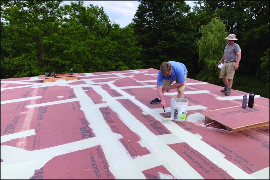 To dry-in the large solar roof project, workers applied base coat and fabric to the Zip System sheathing seams.