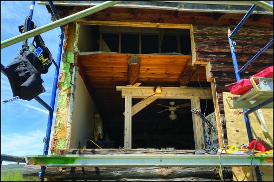 Starting at one end of the rear south-facing bearing wall, the author removed only as much of the log wall as he could replace and seal up in a day.