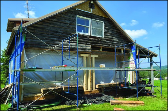 After isolating the living space from the exterior with plastic, the author removed the first-floor log courses. Here, the second-floor center girder (and roof) was supported by small sections of support wall running from the basement to the roof. The suspended upper log coursing stayed in place due its robust nailing (14-inch-long spikes 16 inches on-center).