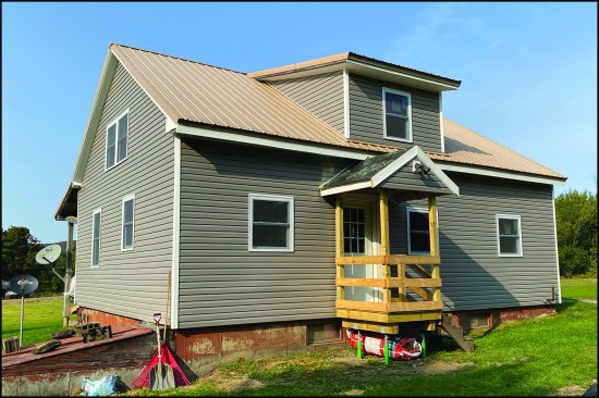 The completed home, clad with vinyl siding.