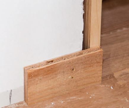 Plywood clips keep the jamb from moving out of the wall plane when the retaining straps are pulled.