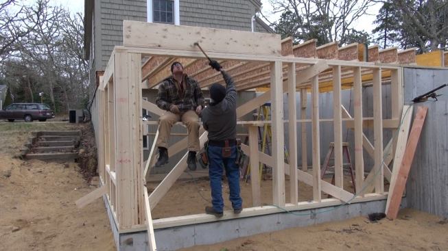 Hill and Laffin frame the first main floor system of the new addition. Here, they work on a header set at the level of the floor frame in the band joist area.