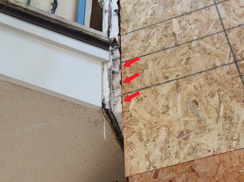 Drainage channels (arrows) were installed horizontally at the band-joist area on this house, blocking the vertical channels above. (We had already replaced the sheathing visible here, since the trapped water had rotted out the original OSB.)