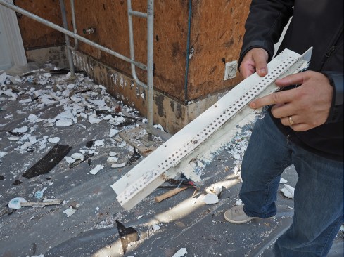 Heavy caulking blocked the weep holes in this plastic track installed at the bottom of the drained EIFS on the wood walls. The trapped water caused water staining all along the bottom of the wall, visible in the background.