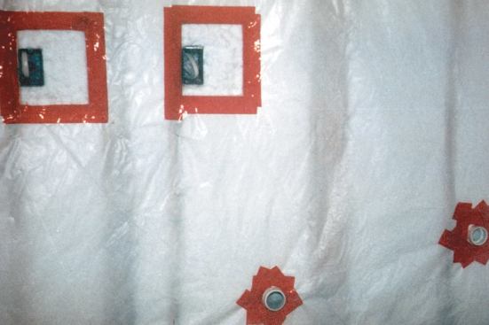 After a wall is insulated, the poly air barrier is taped to the flange of the Lessco box, and the Lessco box is insulated with scraps of fiberglass or cellulose. Note that all plumbing penetrations in the wall are sealed with contractor’s tape.