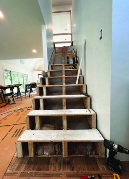 This staircase joining the first and second floors was built with site-made stringers (three main stringers and a fourth, outside stringer). The underside of the stair was drywalled and insulated with batts between the stringers.