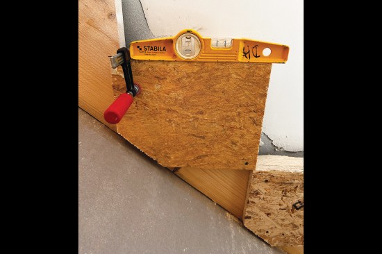 To correct the existing stringers, the author cut 3/4-inch OSB blocks that he then leveled and glued and screwed to the stringers. On this project, the stair is finished with drywall on its underside, which necessitated having to chamfer one corner of each block for clearance.