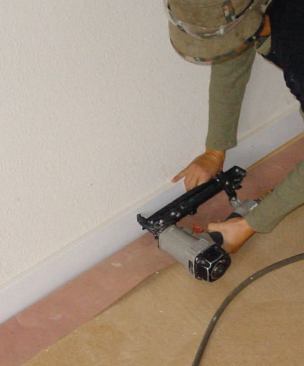 The hardboard floor covering is left in place for the duration of the job; the rosin paper can be folded out of the way to attach new baseboard, then taped back in place to prevent damage to the new base.