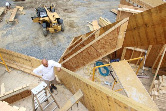 Production manager Mike Dutra standing at the base of an LVL valley rafter for the massive roof frame during construction.