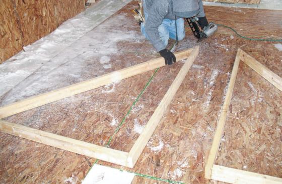 Wall Layout: We laid these right-angle assemblies along the edges of the OSB to keep them square, then simply pulled the length of the bottom plates (the hypotenuse of the triangle) with a tape measure — no calculation necessary.