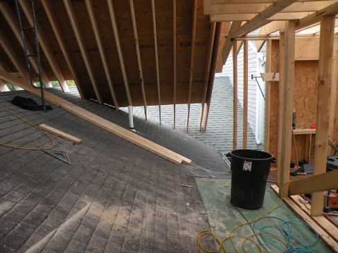 At some locations in the new roof structure, rafters bear on existing roof areas that will be left in place when the addition is complete. Meantime, the sheltered area under the new roof is a convenient workspace. DiGiammo plans to leave the existing roof intact until the upper roof and its supporting walls are complete and the area beneath the new roof is fully enclosed and dried in.