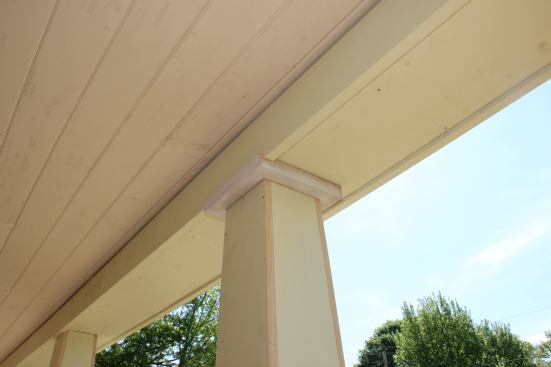 The location of the porch top was dictated by structural considerations. Here, the crew is experimenting with a trim solution for the upper termination of the columns, which was ultimately rejected in favor of an untrimmed column top.
